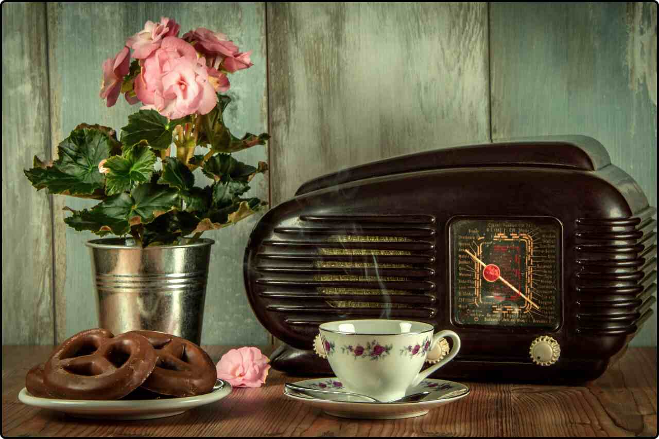 Charming arrangement of a retro radio, coffee, and pretzels on a table.